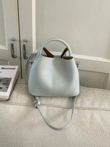 Minimalist light blue bucket bag in lychee pattern leather with top handle and strap