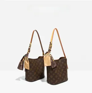 Vue détaillée de sacs seaux monogramme marron foncé avec foulards en soie et bandoulières