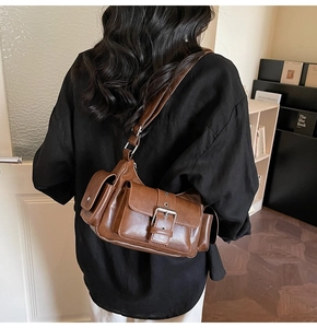 Detail view of retro brown multi-pocket shoulder bag with silver buckles and PU leather finish