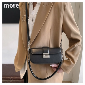 Detailed view of black leather crossbody bag with silver buckle on a model for daily use