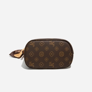 Détail du sac seau marron foncé avec imprimé monogramme et foulard décoratif