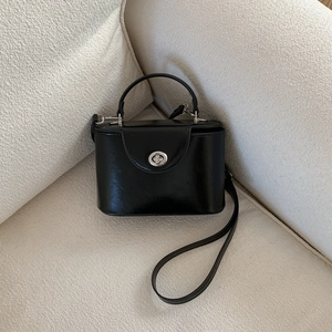 Dettaglio di una borsa quadrata vintage nera con chiusura in metallo argento sul divano