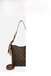 Détail du sac seau vintage avec imprimé monogramme classique et foulard sur la poignée