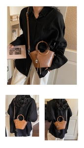 Détail du sac seau vintage marron avec poignée métallique et pompon pour femme
