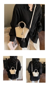 Vue triple du sac seau en cuir crème avec poignée anneau et pompon en forme de cœur