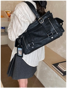 Detail of vintage black matte shoulder bag featuring silver buckle and a small card holder