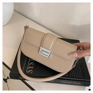 Detail view of the beige leather shoulder bag with its polished silver metal buckle