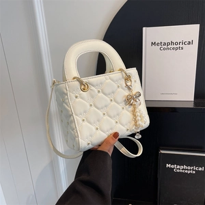 Elegant quilted white mini square bag with pearl bow charm and gold hardware detail