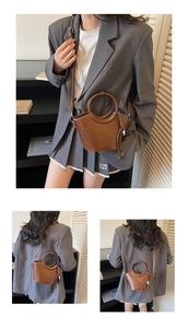 Détail d'un sac seau en cuir marron avec anse ronde et décoration à franges tressées