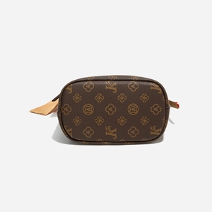 Vue détaillée du fond ovale et du motif monogramme vintage sur le sac en cuir marron