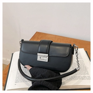 Close-up of black matte leather shoulder bag with silver clasp and chain detail