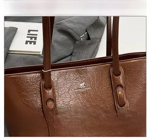 Detail der braunen Shopper-Tasche aus gewachstem Leder mit Känguru-Metalllogo