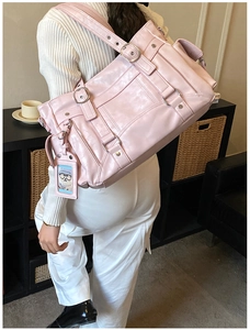 Pink vintage hobo bag with multiple zip pockets and wide strap worn by a model