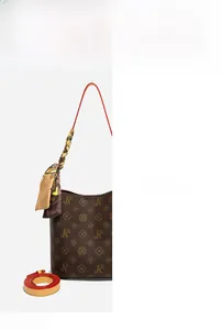 Gros plan du sac seau marron avec poignée en foulard de soie et bandoulière réglable