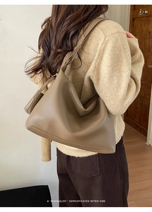Deep khaki pebbled leather tote bag styled on model with a vintage minimalist aesthetic