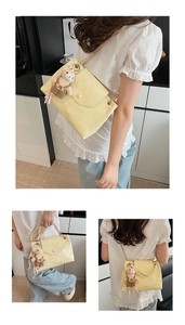 Détail du sac en cuir jaune avec bord ondulé, chaîne dorée et breloque ours en peluche