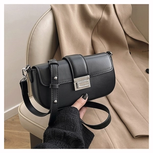 Detail of black leather underarm bag with silver square lock and adjustable strap