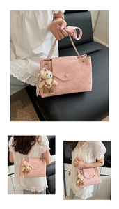 Détail du sac en cuir plissé rose avec bandoulière dorée et petit ours peluche