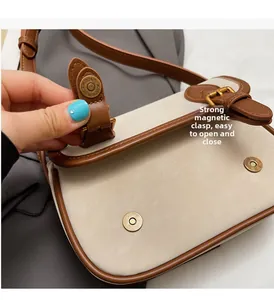 Détail des boucles magnétiques sur un sac baguette vintage en similicuir bicolore