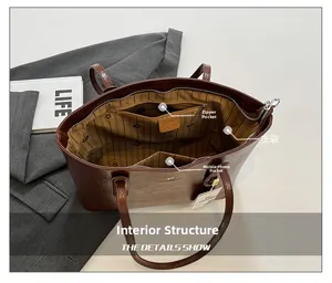 Innenansicht der braunen Shopper-Tasche mit Reißverschlussfächern und gestreiftem Futter