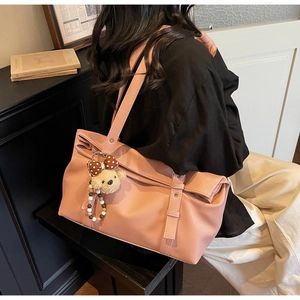 Détail du sac cabas en cuir grainé rose avec un charmant pendentif d'ours en peluche