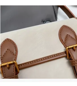 Détail du cuir grainé crème avec sangles brunes et boucles dorées au style vintage