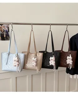 Detailed display of four color tote bags in blue, apricot, black, and brown with bear charms