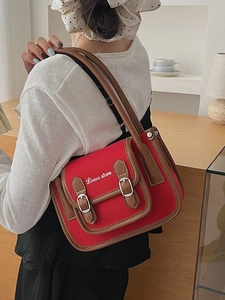 Retro red canvas shoulder bag with brown leather trim and metal buckles shown on model