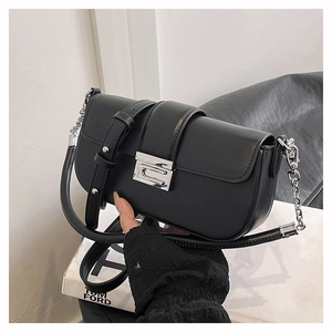 Detail of black leather shoulder bag featuring a silver G-shaped clasp and chain strap