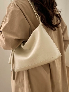 Cream soft leather hobo tote bag with lychee texture shown on female model back