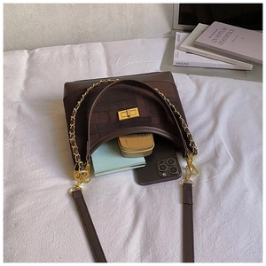 Top view of brown contrast bag interior with smartphone, compact powder and wallet