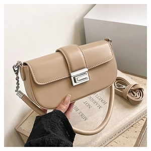 Detail of beige leather small square bag with silver metal twist lock and shoulder strap