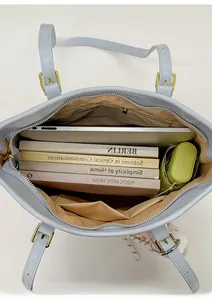 Top view of spacious interior of light blue tote bag showing laptop and daily essentials