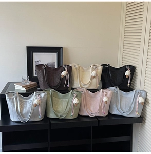 Collection of seven colorful faux suede tote bags displayed with cute crochet charms