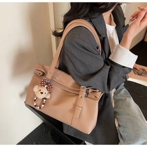 Détail du sac cabas en cuir grainé marron avec boucle argentée et breloque ourson