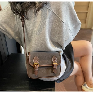 Gros plan sur un mini sac baguette rétro avec brides en cuir brun et boucles