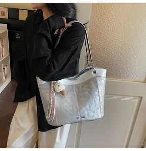 Detailed view of silver metallic tote bag with vintage texture and ice cream charm
