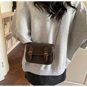 Détail du sac bandoulière vintage marron foncé en similicuir avec boucle et ferrures en laiton