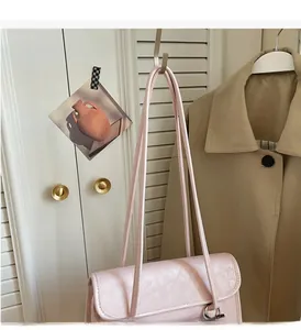 Detail view of pink faux leather shoulder bag texture and metallic ring hardware