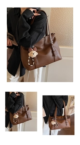 Détail du sac cabas en cuir marron foncé avec bandoulière réglable et breloque ours