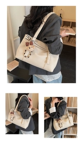 Détail du sac cabas en similicuir beige avec fermeture éclair et charm d'ours mignon