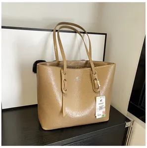 Detail einer braunen Leder-Shopper mit Vintage-Faltenstruktur und silbernem Markenlogo