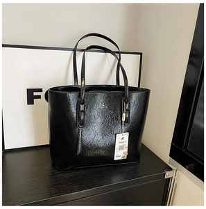 Detailaufnahme der schwarzen Shopper-Tasche mit glänzender Lederstruktur und Narbung
