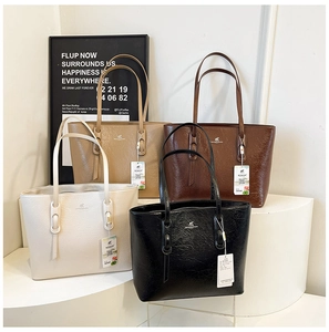 Detailansicht vier minimalistischer Tragetaschen in Creme, Beige, Braun und Schwarz mit Glanz