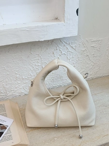 Chic cream white pebble leather handbag with bow detail and silver metallic sphere charm