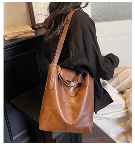 Détail latéral d'un grand cabas vintage marron avec surpiqûres et bandoulière longue