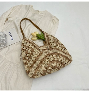 Détail du grand sac cabas en paille bicolore avec motifs évidés et bandoulière en cuir
