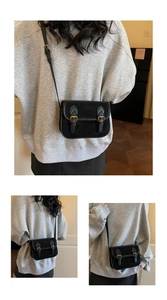 Détails d'un sac bandoulière vintage noir avec double boucle et finition cuir mat