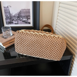 Close-up of two-tone handmade straw weave texture and brown leather strap on tote bag