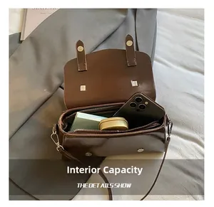 Detail view showing internal capacity of the brown vintage crossbody bag with a smartphone